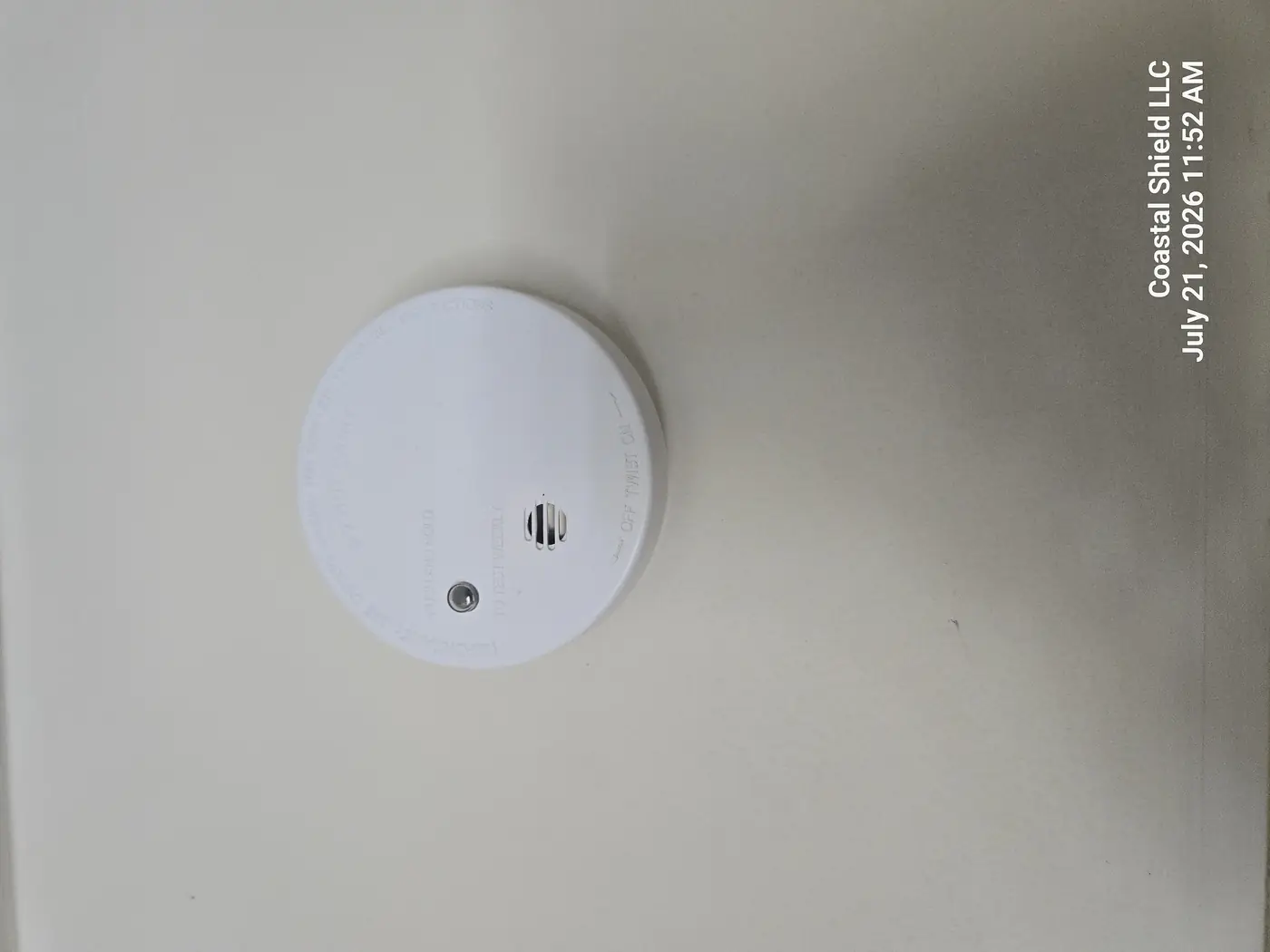Yellowed, decades-old smoke alarm on a ceiling