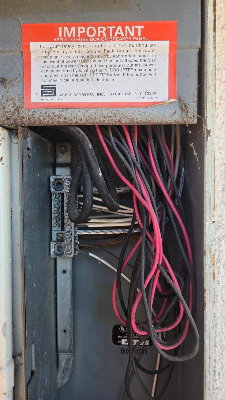 Heat damage and scorching visible on the neutral bus bar inside a Zinsco electrical panel.