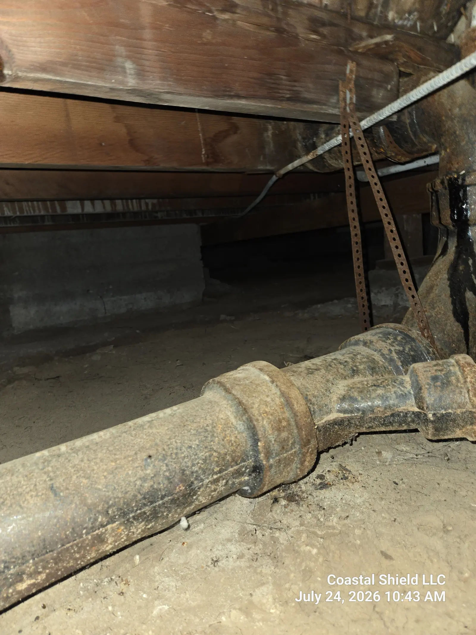 Original cast-iron drain line with corroded strapping beneath a historic Santa Barbara home