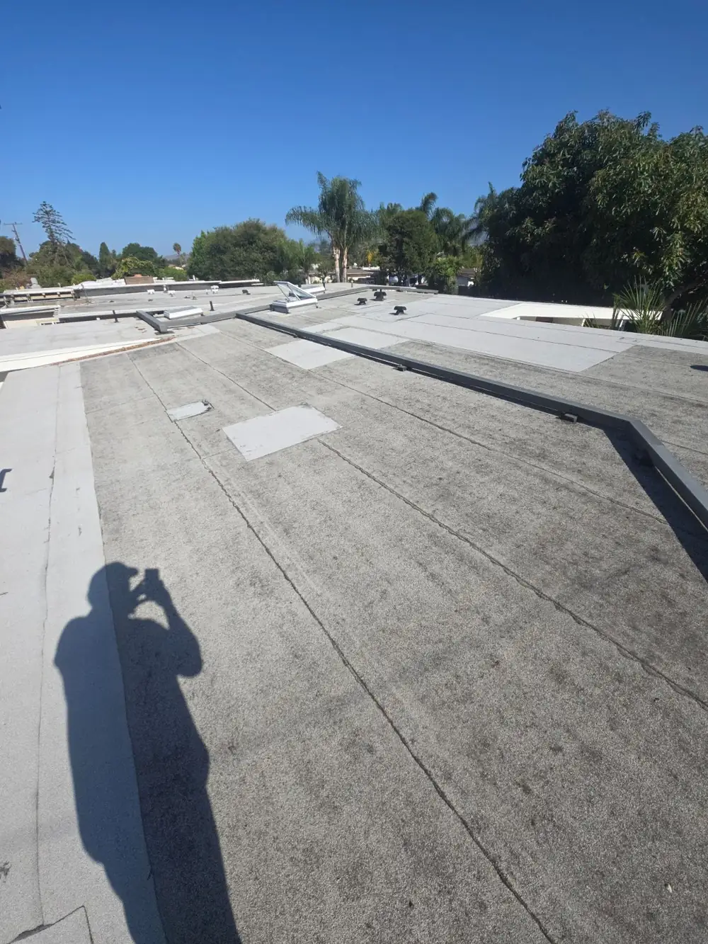 Mineral-surfaced flat membrane roof with patch repairs, walked during an inspection