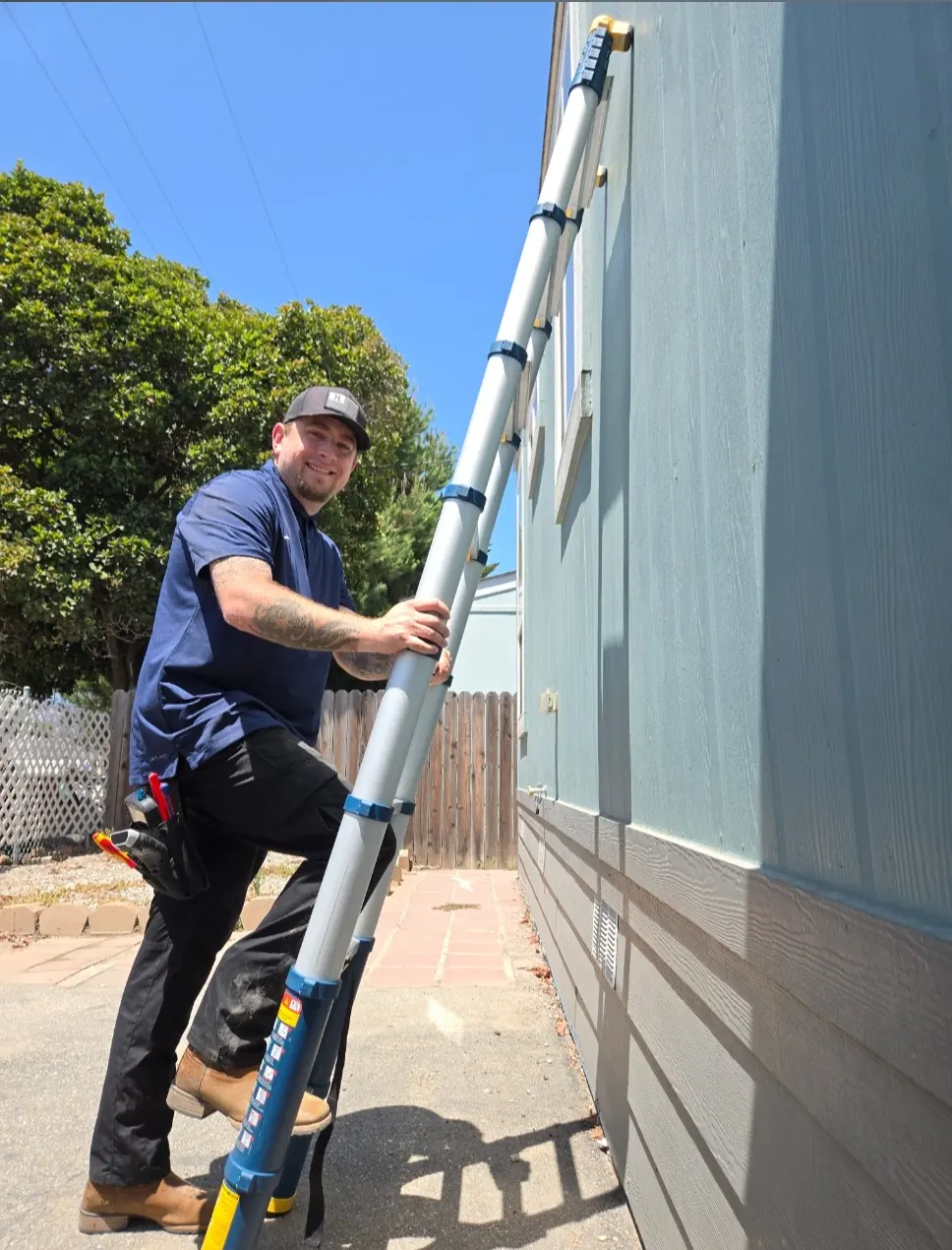 Louis O'Connor on a telescoping ladder heading up to inspect a roof edge