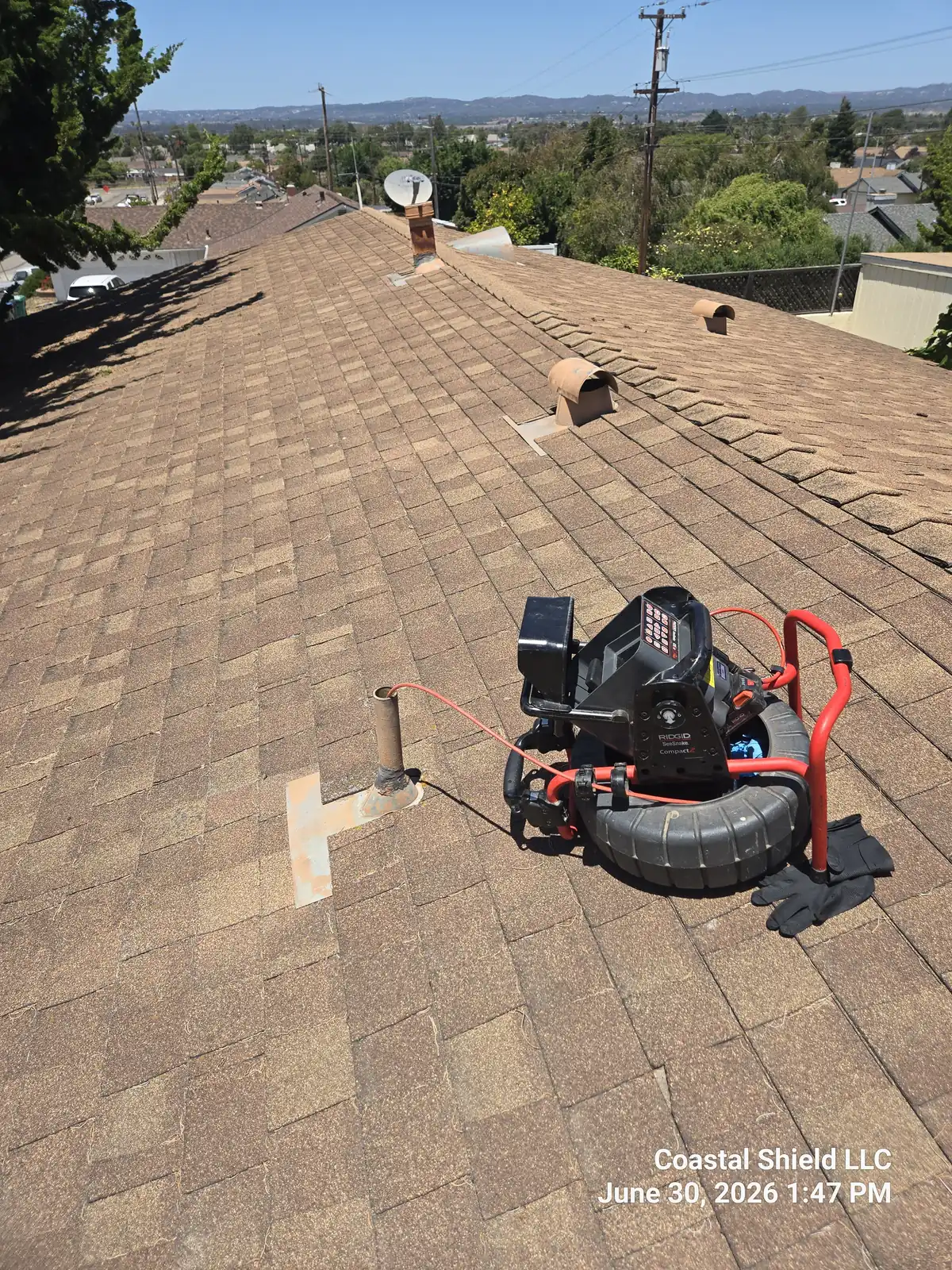Our RIDGID SeeSnake camera reel set up on a roof, scoping the sewer line through the vent stack